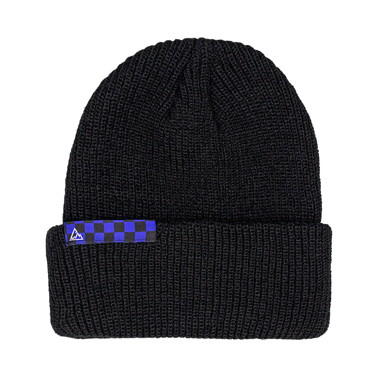 A black knitted beanie with a ribbed pattern, featuring a blue and black checkered patch on the folded cuff with a small triangular logo.