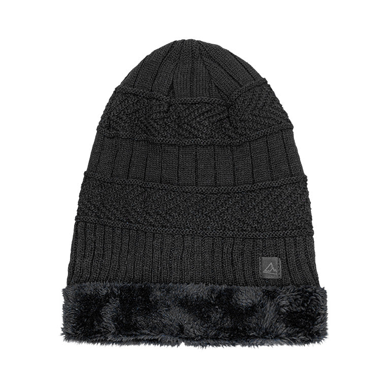 A black heavy knit beanie with a cable knit pattern, a ribbed fold-over cuff, and a fluffy black faux fur band above the cuff. It has a small triangular logo patch on the cuff.