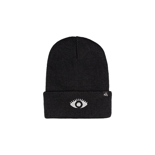 A black ribbed beanie with a white eye patch on the fold and a small triangular logo patch.