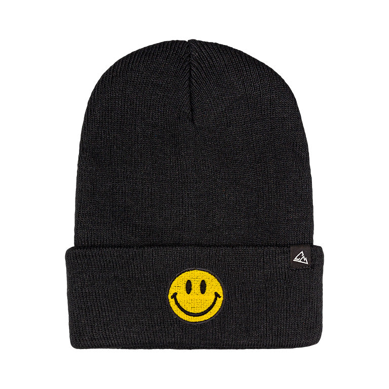 A black ribbed beanie is adorned with a yellow smiley face patch on the fold, complemented by a small triangular logo.