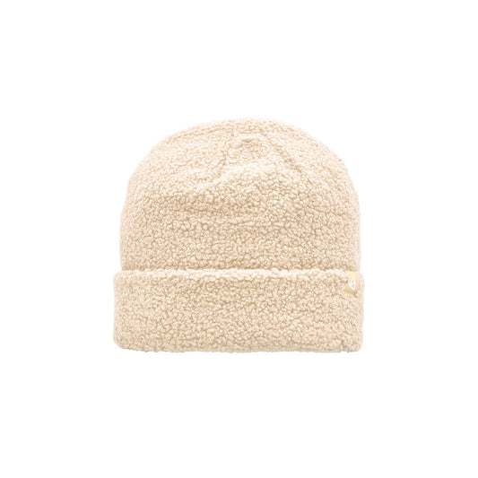 This is a cream-colored sherpa beanie with a plush, textured look and a small triangular logo patch on the cuff.