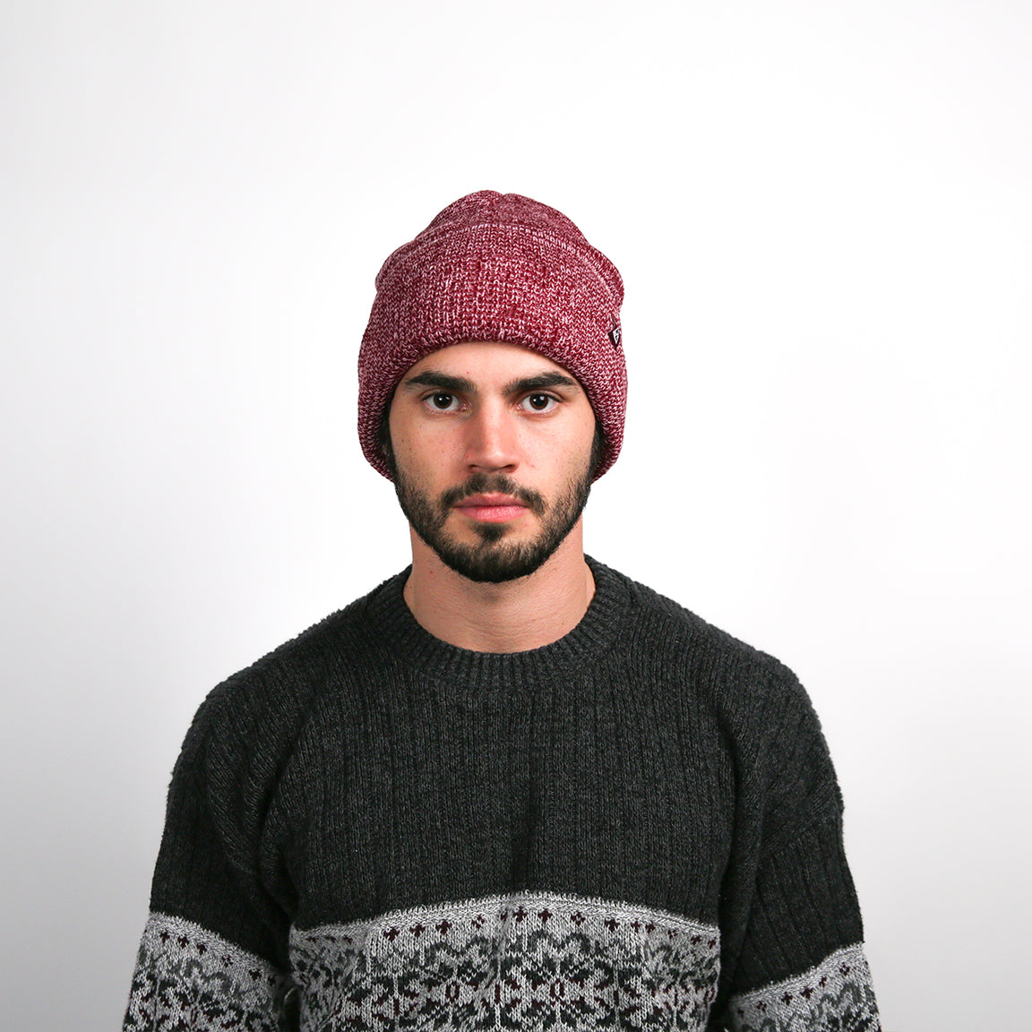 A person is wearing a loosely fitted, heathered knit beanie in a deep burgundy shade, providing a contemporary and fashionable appeal.